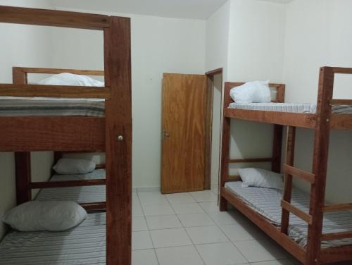 a room with three bunk beds and a mirror at AM-RR Hostel in Manaus