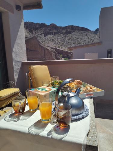 a table with a tea kettle and glasses of orange juice at Möller Masi in Purmamarca