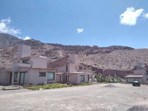 um grupo de casas em frente a uma montanha em Möller Masi em Purmamarca