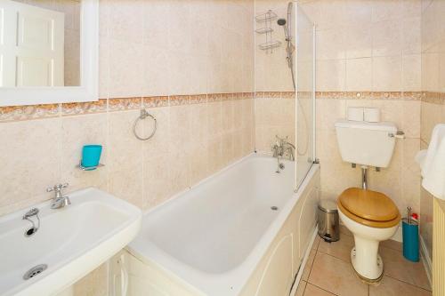 a bathroom with a tub and a toilet and a sink at Welcoming Flat By Kasar Stays in Gillingham