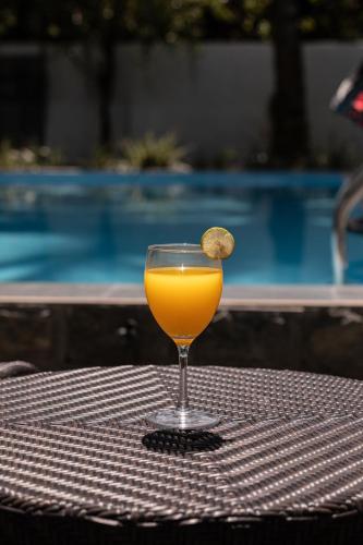 a glass of orange juice sitting on a table at Villa Windfall Unawatuna in Unawatuna
