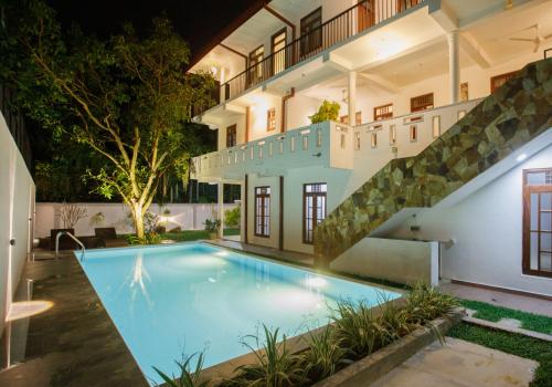 an indoor swimming pool in a house with a staircase at Villa Windfall Unawatuna in Unawatuna