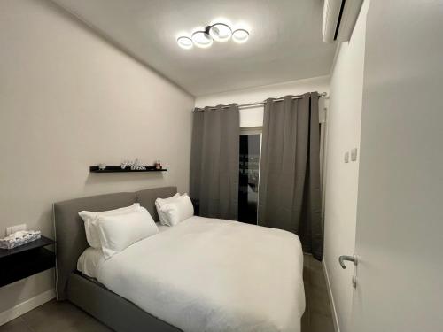 a bedroom with a bed with white sheets and pillows at Sweet RHome - A due passi da San Pietro in Rome