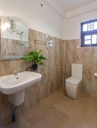 a bathroom with a sink and a toilet at Villa Windfall Unawatuna in Unawatuna