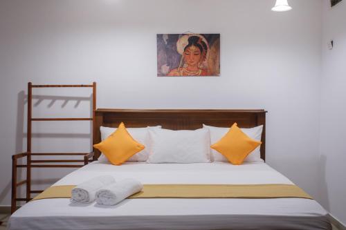 a bedroom with a bed with two towels on it at Villa Windfall Unawatuna in Unawatuna