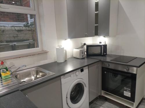 uma cozinha com uma máquina de lavar roupa e um micro-ondas em Large 'n' Bright Room em Middlesbrough