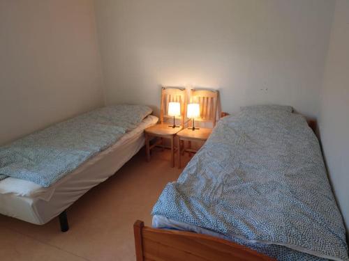 two beds in a room with two lamps on tables at Large Apartment, Quality Company Accommodation. in Sundsvall