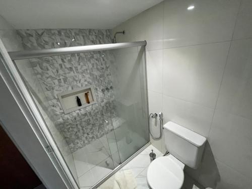 a white bathroom with a shower and a toilet at VICTÓRIA MARINA FLAT - vista avenida in Salvador