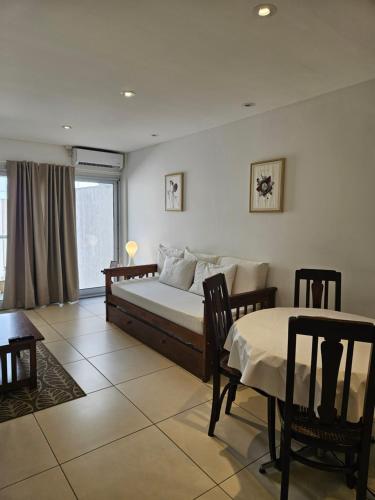 una camera da letto con un letto, un tavolo e delle sedie di Pina a Mar del Plata