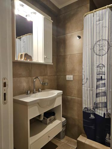 un bagno con lavandino e tenda da doccia di Pina a Mar del Plata