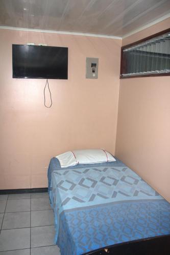 a bedroom with a bed and a flat screen tv at Hotel El Dorado in San José