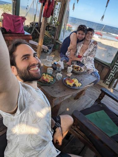 un grupo de personas sentadas en una mesa comiendo comida en Para un poquito relax en Barra de Valizas