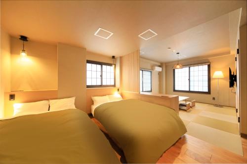 Yutorelo Tsuwano في Tsuwano: غرفة نوم بسريرين واريكة
