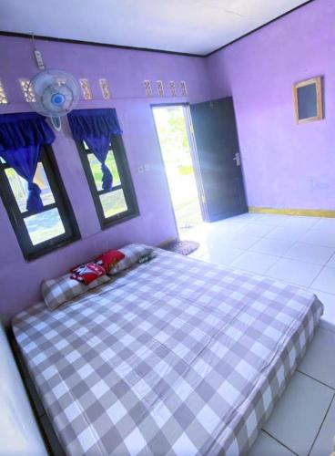 a purple bedroom with a large bed in a room at Penginapan & Homestay Geopark Ciletuh in Cikadal
