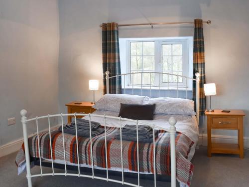 a bedroom with a bed and two night stands at Lower Farm in Llanfihangel Rhydithon