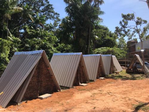 a row of metal roofs on a dirt field at Toninhas Camping Ubatuba in Ubatuba