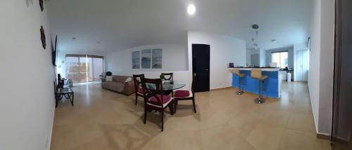 een grote woonkamer met een tafel en stoelen bij Relajate en un hermoso apartamento Duplex cerca de la playa y piscina en Playa Blanca, Farallon in Río Hato