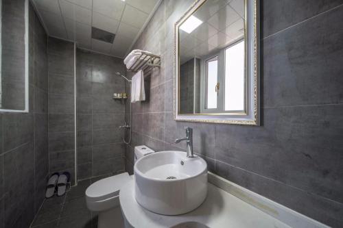 a bathroom with a sink and a toilet and a mirror at 恩施硒坪民宿 Enshi Xiping Homestay in Enshi