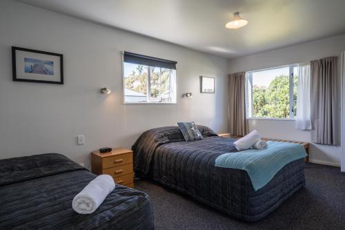 una camera d'albergo con due letti e una finestra di Fitzherbert Court Motel a Hokitika