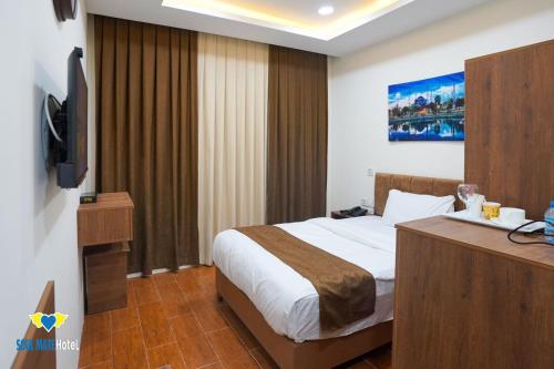 a hotel room with a bed and a television at Soulmate Hotel Erbil in Erbil