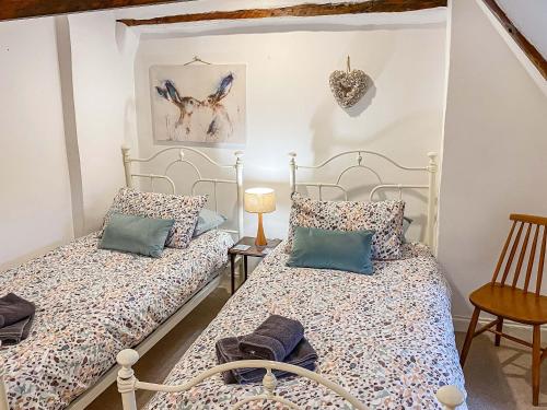a bedroom with two beds and a table at Nells Cottage in Bridlington