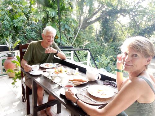 an older man and woman sitting at a table eating food at Green turf in Galle