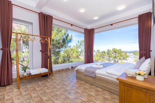 a bedroom with a bed and a large window at Villa Đà Lạt View Thông in Khu Chi Lăng