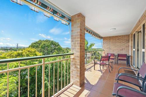a balcony with chairs and tables with a view at Bright & Breezy ~ 2 Bed/2 Bath /1 Car/ Views! in Brisbane