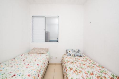 2 Betten in einem Zimmer mit Fenster in der Unterkunft Rental Palhoça- Acomodações Residenciais IV in Palhoça