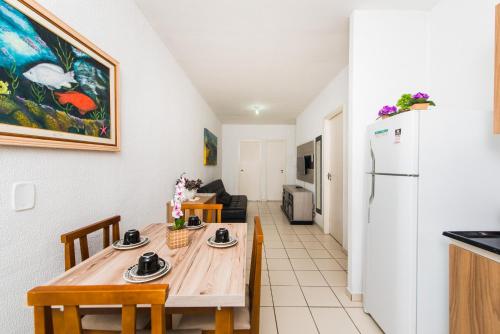 帕羅卡的住宿－Rental Palhoça- Acomodações Residenciais IV，厨房以及带桌子和冰箱的用餐室