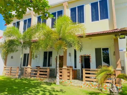 a house with palm trees in front of it at Oceanfront Beach Resort in Siquijor