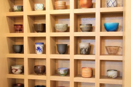 a shelf filled with bowls and other pottery at Yutorelo Tsuwano in Tsuwano