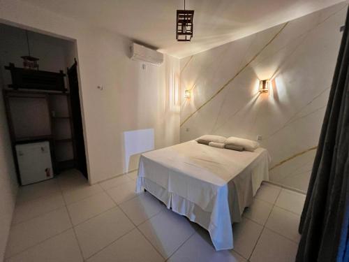 a bedroom with a bed and a wall at Maceió Kite House in Camocim