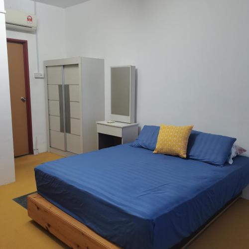Un dormitorio con una cama grande con una manta azul. en Homestay Cik Tein Kuala Terengganu, en Kuala Terengganu