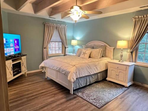 a bedroom with a bed and a flat screen tv at LakePath Beach House - XL hot tub, walk to beach in Coloma