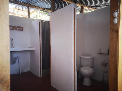 a bathroom with a toilet in a white wall at Linda vista in San Pedro La Laguna