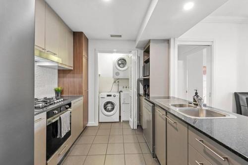 a kitchen with a washing machine and a washer and dryer at Prime Position! 3Bed/2Bath/1Car ~ 10mins to CBD in Brisbane