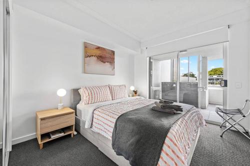 a white bedroom with a bed and a chair at Prime Position! 3Bed/2Bath/1Car ~ 10mins to CBD in Brisbane