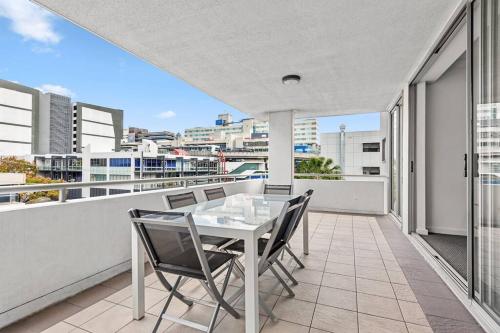 a balcony with a glass table and chairs on a building at Prime Position! 3Bed/2Bath/1Car ~ 10mins to CBD in Brisbane