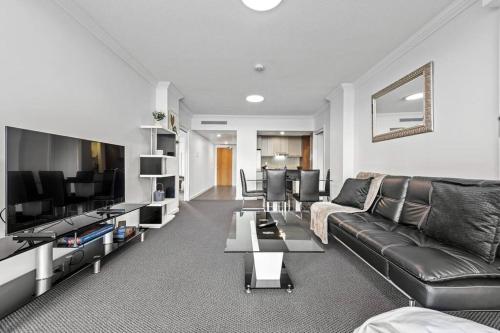 a living room with a couch and a television at Prime Position! 3Bed/2Bath/1Car ~ 10mins to CBD in Brisbane