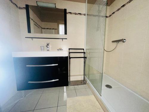 une salle de bain avec un lavabo, une douche et un miroir dans l'établissement Appartement T3 à Collioure, 200m de la plage, résidence calme avec parking et balcons - FR-1-309-417, à Collioure