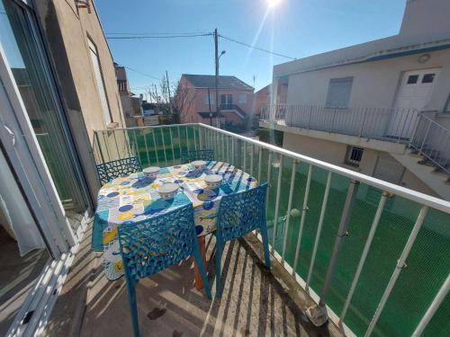 d'un balcon avec une table et des chaises. dans l'établissement Appartement T2 à Marseillan Plage : terrasse, jardin, parking, proche plage et commerces - FR-1-326-796, à Marseillan