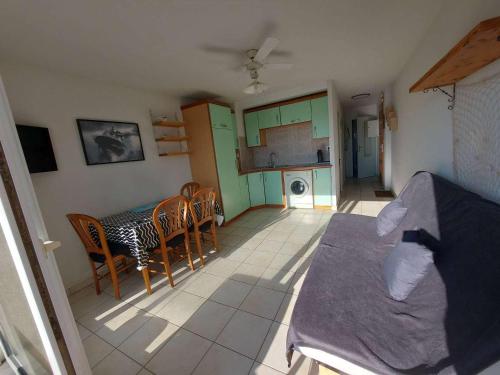 une cuisine et une salle à manger avec une table et des chaises dans l'établissement Appartement 2P avec Terrasse Sud, Parking, WIFI et Animaux Acceptés à Marseillan - FR-1-326-797, à Marseillan