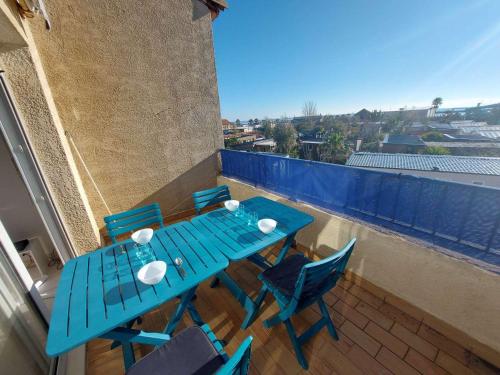 une table bleue et des chaises sur un balcon dans l'établissement Appartement 2P avec Terrasse Sud, Parking, WIFI et Animaux Acceptés à Marseillan - FR-1-326-797, à Marseillan