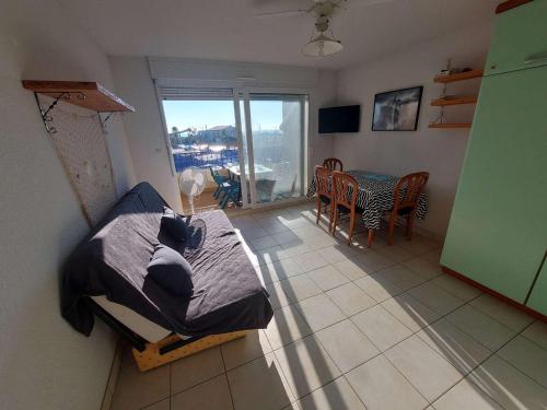 une chambre avec un lit et une salle à manger avec une table dans l'établissement Appartement 2P avec Terrasse Sud, Parking, WIFI et Animaux Acceptés à Marseillan - FR-1-326-797, à Marseillan