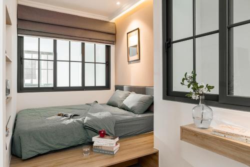 a bedroom with a bed and two windows at M Village Living Hoàng Văn Thụ in Ho Chi Minh City
