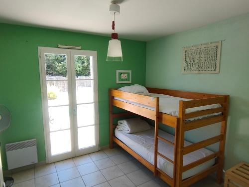Cette chambre aux murs verts comprend des lits superposés. dans l'établissement Maison avec Piscine Privée, Jardin Clos et Parking proche Plage et Forêt à Saint Jean de Monts - FR-1-323-468, à Saint-Jean-de-Monts