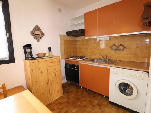 une cuisine avec un évier et une machine à laver dans l'établissement Maison de Vacances P3, 5 Couchages, Climatisée, Terrasse ensoleillée, Parking privé, Proche Plage et Commerces - FR-1-307-248, au Grau-du-Roi
