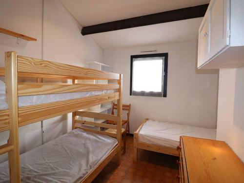 une chambre avec deux lits superposés et une fenêtre dans l'établissement Maison de Vacances P3, 5 Couchages, Climatisée, Terrasse ensoleillée, Parking privé, Proche Plage et Commerces - FR-1-307-248, au Grau-du-Roi