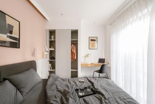 a bedroom with a bed and a desk at M Village Living Hoàng Văn Thụ in Ho Chi Minh City